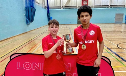 2 students holding a cup